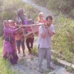A 3-km road has not been constructed for 13 years; the sick are being transported via doli (makeshift stretcher).